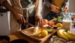 Close up shot of two pairs of hands preparing fruit and vegetables