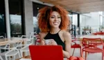 Smiling women with natural curls working on her laptop