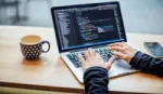 Woman working on coding via a laptop