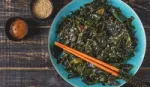 A photograph of a bowl of vegetables with some chopsticks.