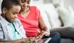 Mother and son working at computer. Hygienica Castle uses online games to teach hygiene lessons to children.