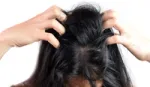 Lady with dark hair scratching head. Unilever research finds bacteria that causes dandruff.